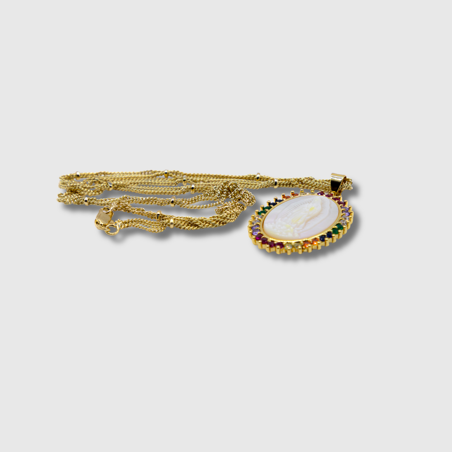 Medalla Virgen de Guadalupe de concha con aro piedras de colores.