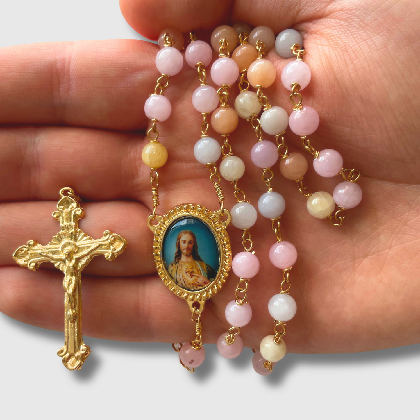 Rosario de piedra color rosa arcoiris con crucero doble imagen, baño de oro 24 k.