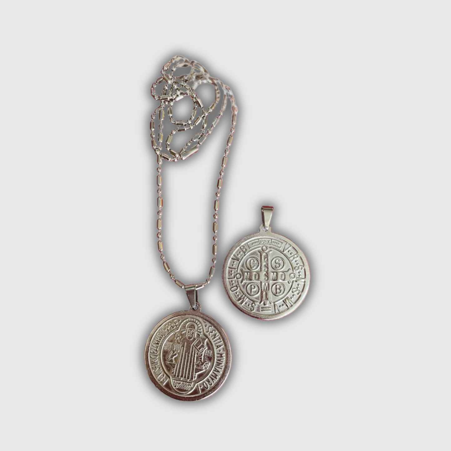 Medalla San Benito de acero plateada con cadena.